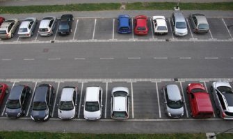 Političar ključevima grebe automobile na parkingu