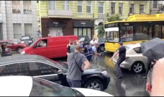 Skočio na Porošenkov automobil, pa dobio udarac kišobranom (VIDEO)